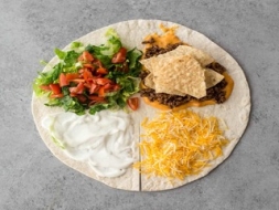 Pasniedz brokastīs tortilju ar dažādu pildījumu